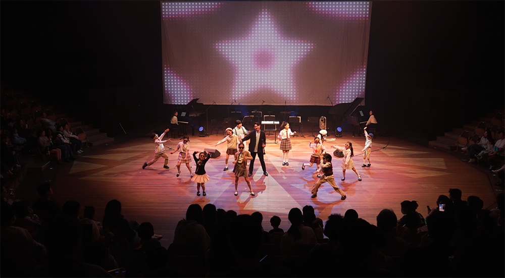 자연이랑 클래식 콘서트 - 생상스 할아버지의 선물’ 공연에서 클라리넷 연주자가 어린이 배우들과 함께 안무를 선보이고 있다.png