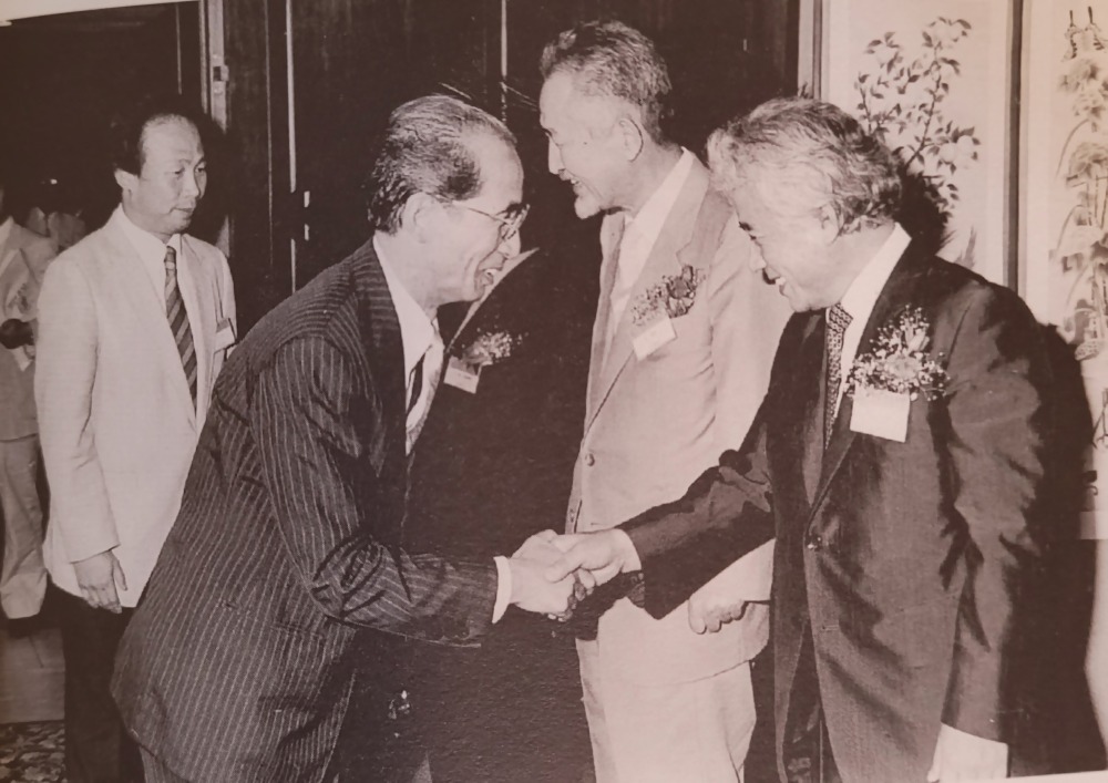 아시아 시인회의 행사에서 악수하는 김광림과 다카하시 기쿠하루, 시인 구상과 오세영도 보인다.-2.jpg